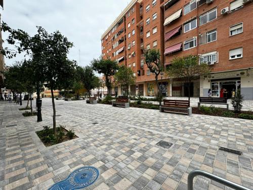 a cobblestone street with benches and a building at Rodrigues 15 in Valencia