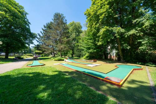 a row of trampols in a park with trees at Hôtel du Parc, Restaurant, Spa & Wellness in Niederbronn-les-Bains