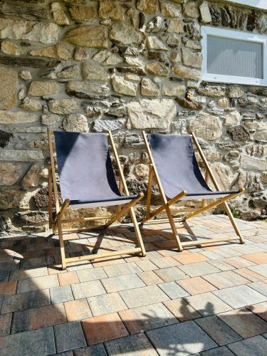two folding chairs sitting in front of a stone wall at Fuchsbau in Vordertheissenegg