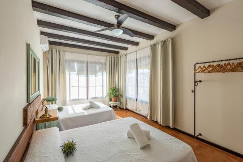 a bedroom with two beds and a large window at Casa Rural La Teja in Marchena