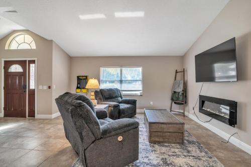 a living room with two chairs and a tv at Micanopy Lake Retreat home in Micanopy