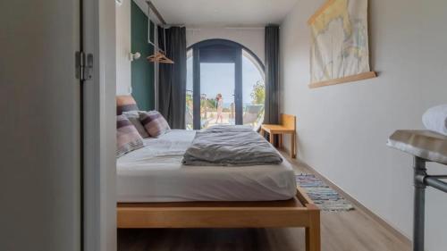 a bedroom with a bed in a room with a window at WOT Ericeira Surf Hostel in Ericeira