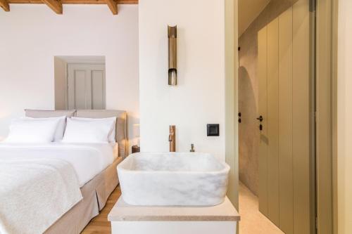 a bedroom with a bath tub next to a bed at Maison Muse in Hydra