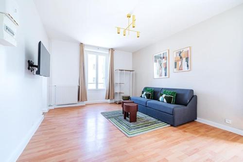 un salon avec un canapé bleu et une télévision dans l'établissement Appartement spacieux et calme Ville de Issy, à Issy-les-Moulineaux