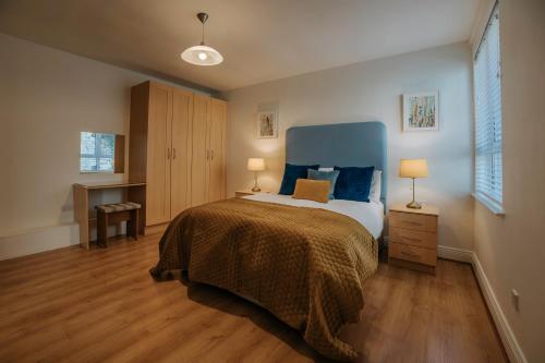a bedroom with a bed with a blue headboard at Killiane Castle Country House & Farm in Wexford