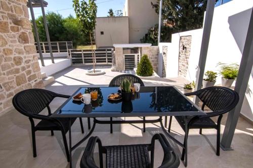 a table and two chairs on a patio at Mirabilia Family House in Pitsidia