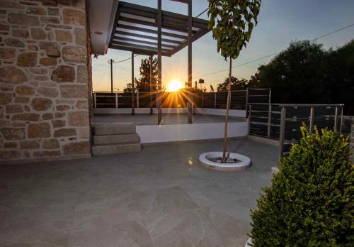 a view of a sunset from a patio with a tree at Mirabilia Family House in Pitsidia