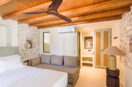 a bedroom with a bed and a ceiling fan at Maison Muse in Hydra