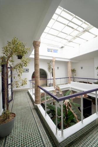 a room with a table and trees in it at Riad Medina Charme et Sérénité in Essaouira