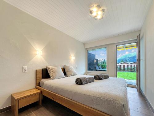 a bedroom with a bed and a large window at Valdor Residence- Crans Montana- Swiss Alps in Crans-Montana