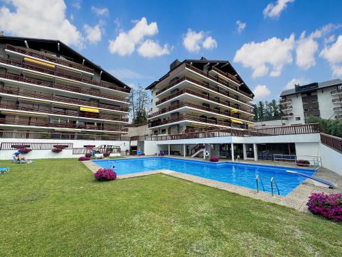 a large apartment building with a large swimming pool at Valdor Residence- Crans Montana- Swiss Alps in Crans-Montana