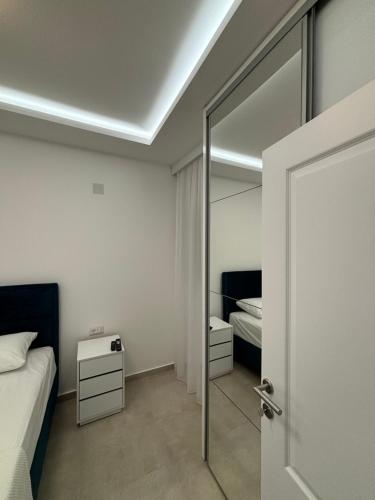 a bedroom with a mirror and a bed and a door at Apartmani Milos - Meljine in Herceg-Novi