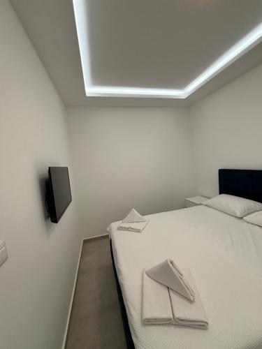 a bedroom with a bed with two towels on it at Apartmani Milos - Meljine in Herceg-Novi