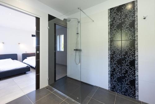 een glazen douche in een badkamer met een slaapkamer bij 30VENTSB Villa Eole in Saint-Ambroix