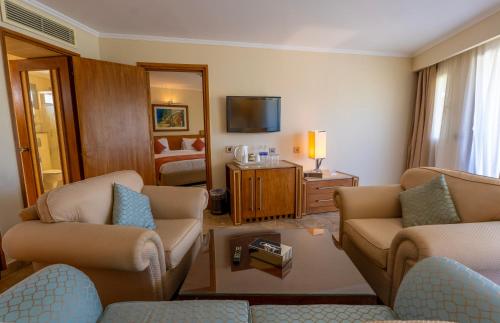 a living room with two couches and a tv at Jolie Ville Hotel & Spa Kings Island Luxor in Luxor