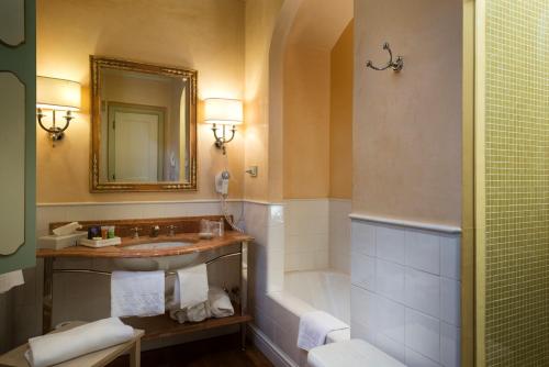 a bathroom with a sink and a tub and a mirror at Posta Donini 1579 - UNA Esperienze in San Martino in Campo
