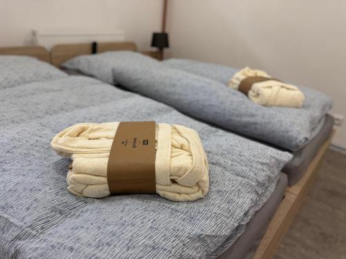 two beds with towels sitting on top of them at U pěti kohoutů in Liberec