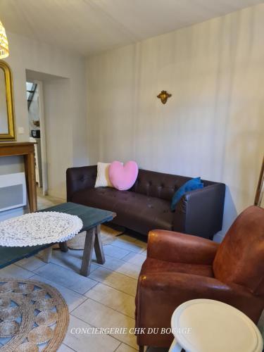a living room with a couch and a table at Logis Philiberte 3 chambres centre bourg des Epesses à 5min du Puy du Fou in Les Épesses