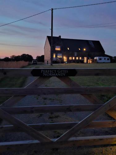 a barn with a sign in front of a building at Perfect Gites In Normandy in Saint-Sauveur-de-Chaulieu
