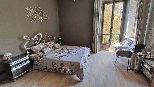 a bedroom with a bed and a large window at Villa Giordana in Casalborgone