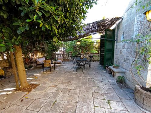 a patio with a table and chairs under a tree at La Dimora di Donna Cecilia in Bari