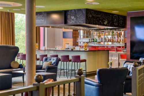 a bar in a restaurant with chairs and a counter at Hilton Garden Inn Stuttgart NeckarPark in Stuttgart