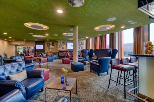 a waiting room with blue furniture and a green ceiling at Hilton Garden Inn Stuttgart NeckarPark in Stuttgart