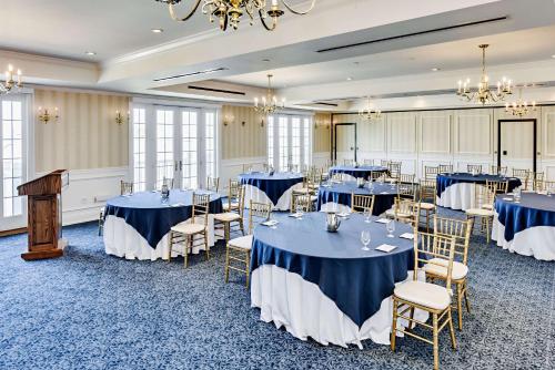 a banquet room with blue tables and chairs at Madison Beach Hotel, Curio Collection by Hilton in Madison