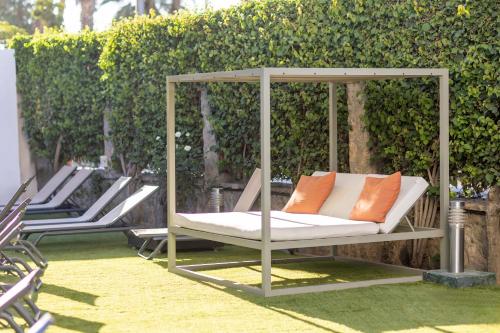a porch swing with two orange pillows on it at Soho Boutique Las Vegas in Málaga