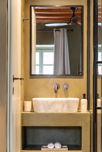 a sink in a bathroom with a mirror at Maison Muse in Hydra