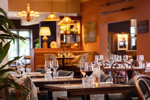 a restaurant with wooden tables and chairs with wine glasses at The Ropemaker - A Heartwood Inn in Emsworth