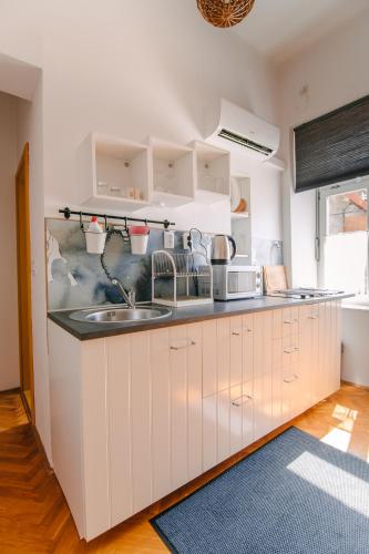 a kitchen with white cabinets and a sink at Apartments SAB in Ogulin