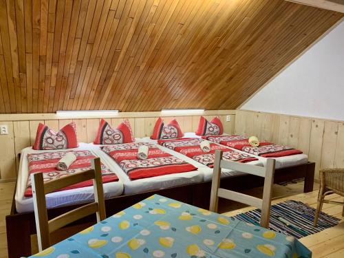 two beds in a room with wooden ceilings at Budget izba pre veľkú rodinu alebo skupinu priateľov in ľubochňa