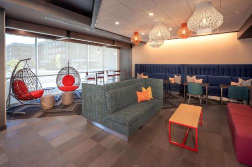 a restaurant with a couch and chairs and tables at Tru By Hilton Yakima Airport in Yakima