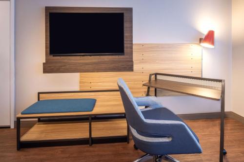 a room with a desk and a chair and a tv at Tru By Hilton Yakima Airport in Yakima