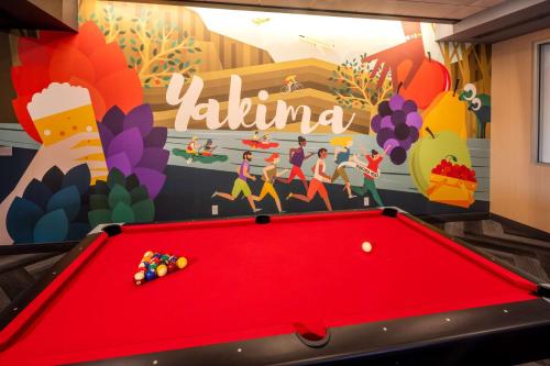 a red pool table in front of a mural at Tru By Hilton Yakima Airport in Yakima