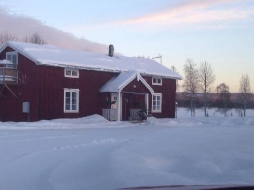 a red barn with snow on top of it at Hus i Lappland in Harads
