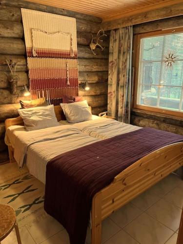 a bedroom with a large bed in a log cabin at Lapland Cabin Levi in Kittilä