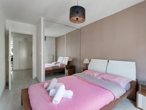 - une chambre avec un lit rose et un grand miroir dans l'établissement Détente et balcon, La Défense-Paris, à Courbevoie