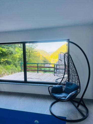 a swing chair sitting in front of a window at Villa Casa de Dina in Bihać