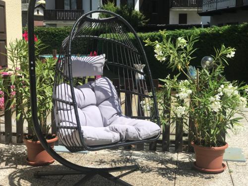 a black chair with pillows in a garden at Maison Laurent in Courmayeur