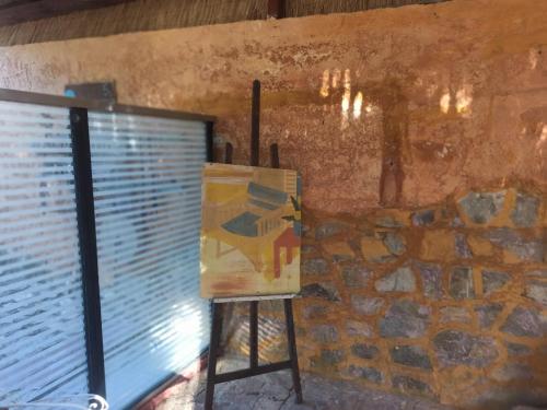 a painting on a stand next to a window at Akros Oreon Houses in Káto Sími