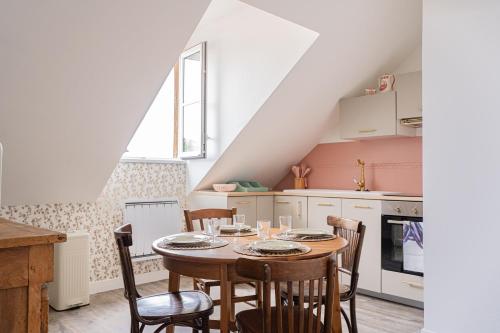 une cuisine avec une table et des chaises dans une pièce dans l'établissement Le cocon de la reine, à Versailles