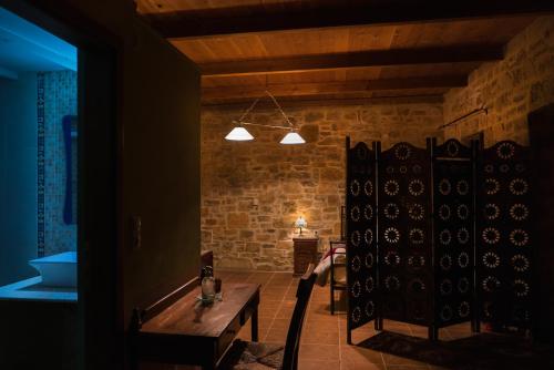 a room with a wooden table and a brick wall at Akros Oreon Houses in Káto Sími
