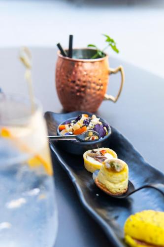 a black plate with a bowl of food and a cup at Bolina Suite & Spa in Milano Marittima