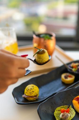 a table topped with black plates with food on them at Bolina Suite & Spa in Milano Marittima