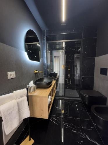 a black bathroom with a sink and a shower at B&B Arcade Luxury in Montepaone Lido