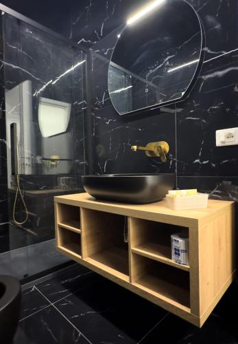a bathroom with a sink and a black wall at B&B Arcade Luxury in Montepaone Lido