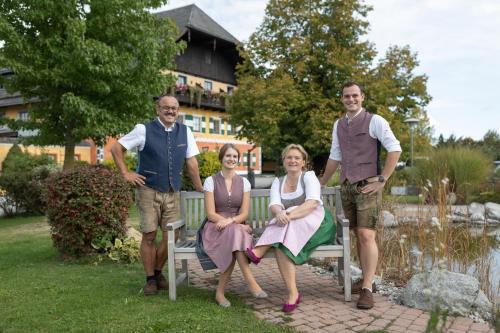 a group of three people sitting on a bench at Gastagwirt in Eugendorf