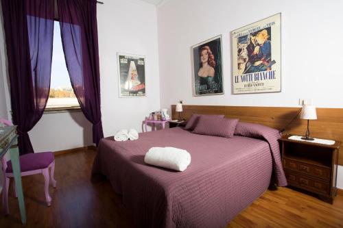 1 dormitorio con cama morada y ventana en Laterano Inn, en Roma